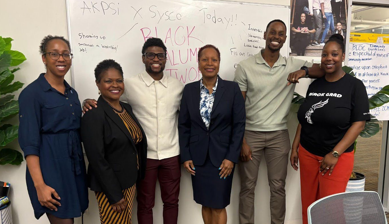 Members of BAN posed together in front of a white board