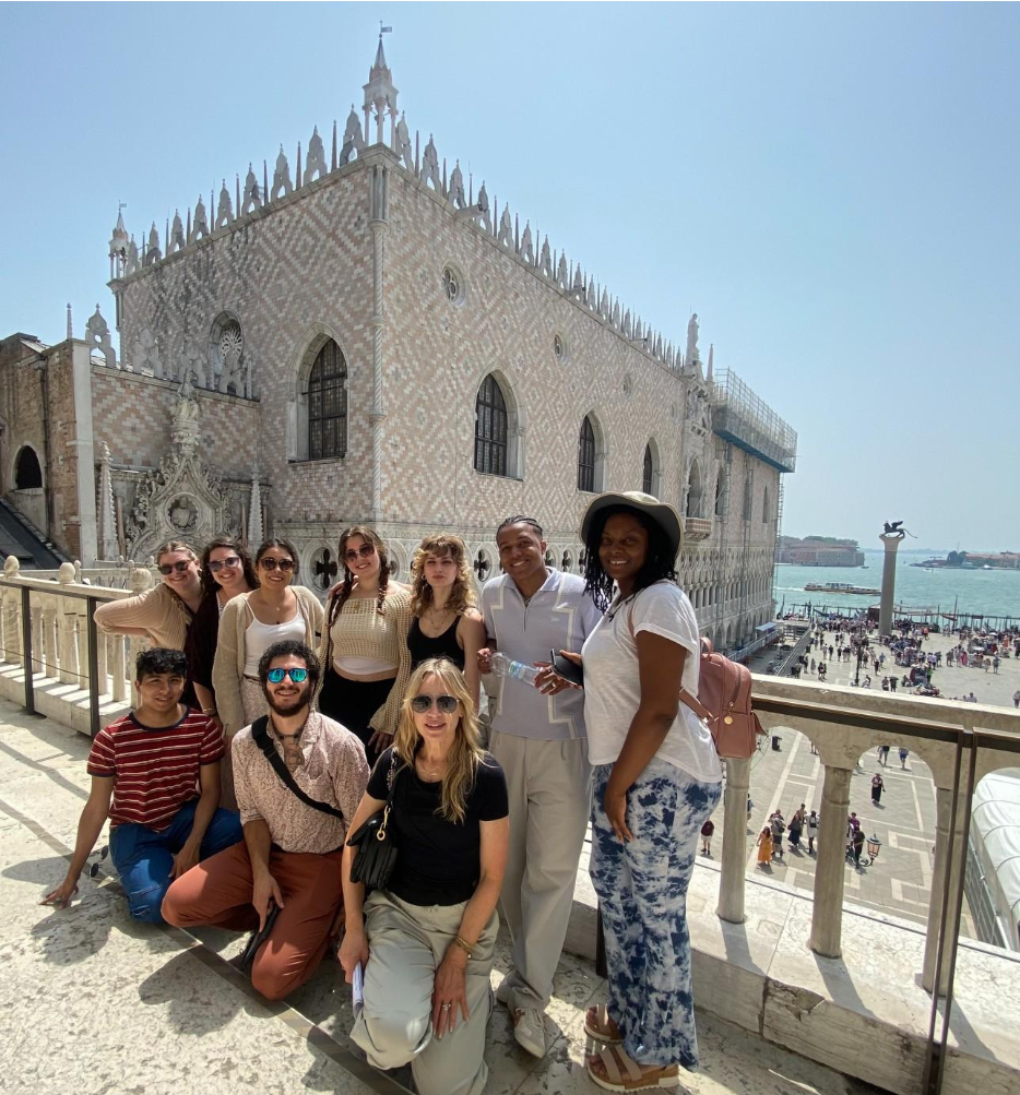 A diverse group of people gathered for a photo in front of an ornate building on the coast. Faculty Led Program - Venice