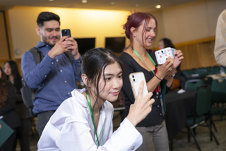 students aim cell phones, taking pictures at celebration