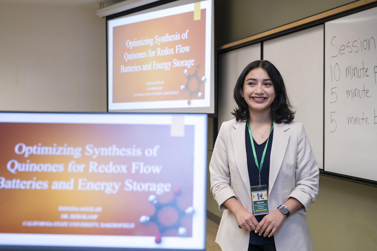 in foreground, computer with presenter loaded.  presenter stands behind it, and you can see the projection screen with the presentation in back